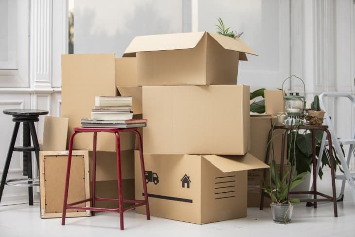 Cardboard boxes and home items stacked in a room during a move.
